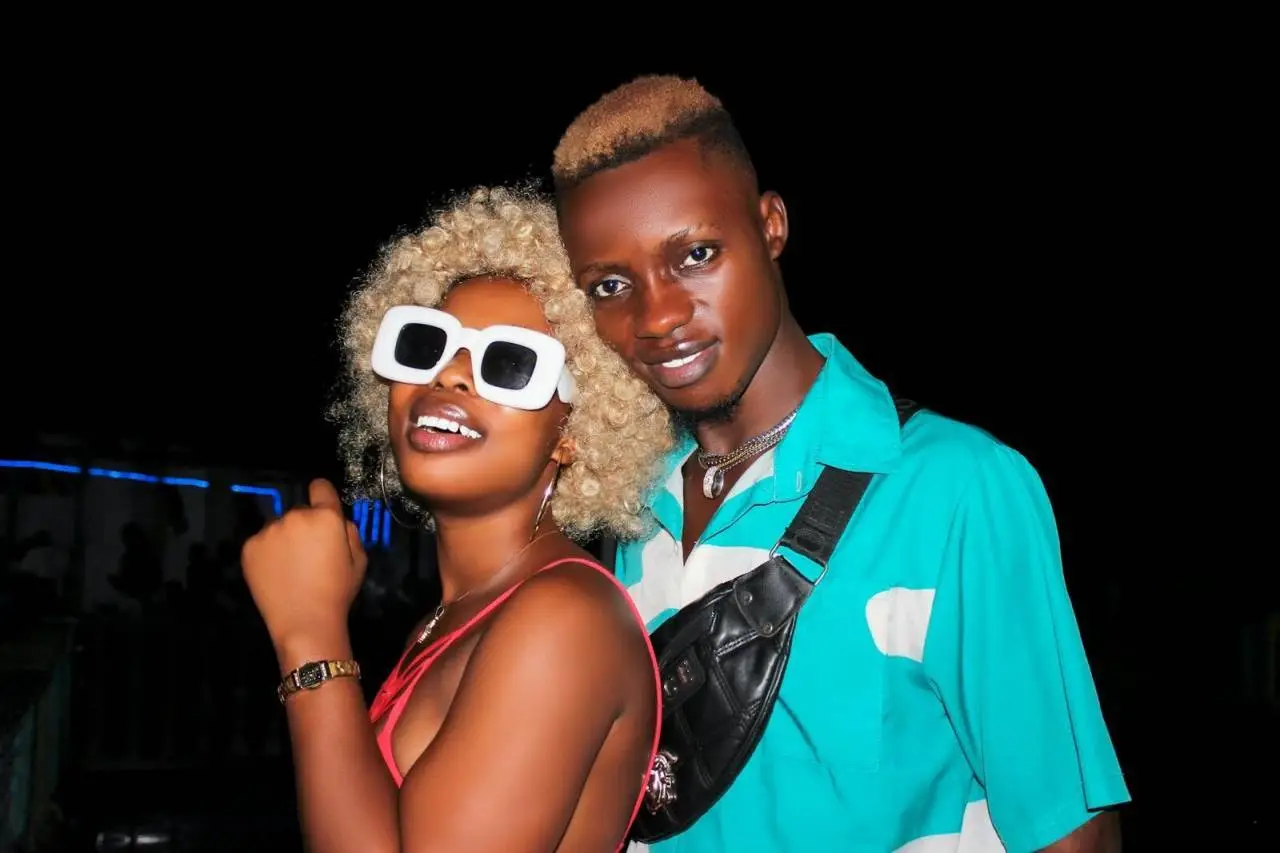 Young couple with sunglasses posing confidently at night.