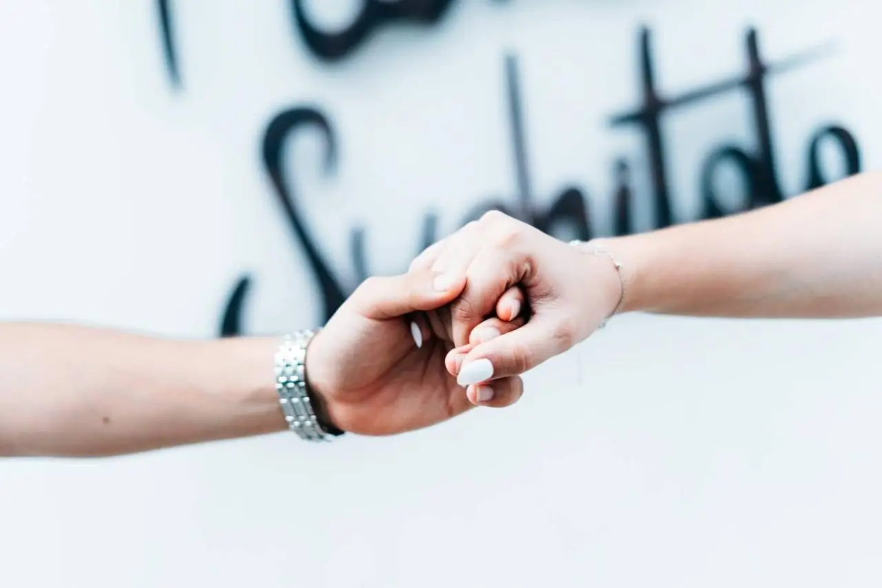 A tender close-up of a couple holding hands with a soft focus background, symbolizing love and unity.