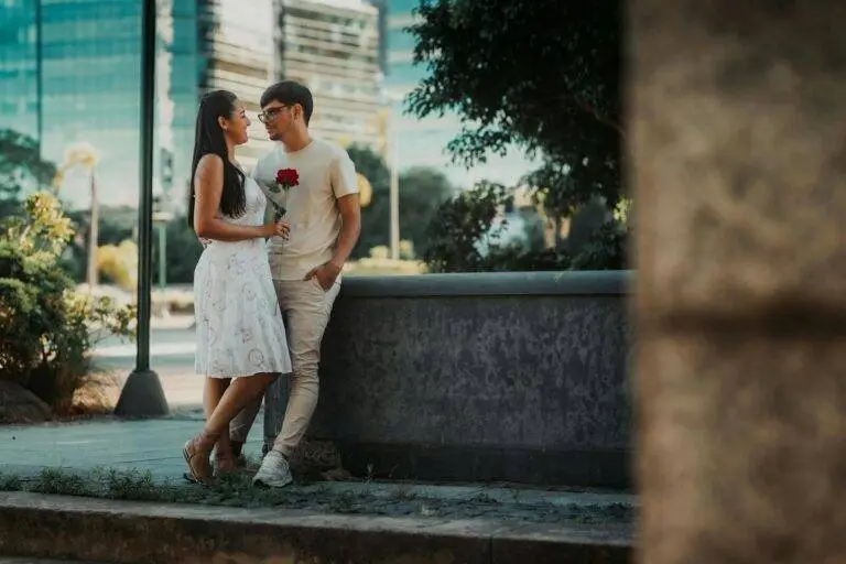 A romantic couple sharing a moment with a rose in a Buenos Aires park.