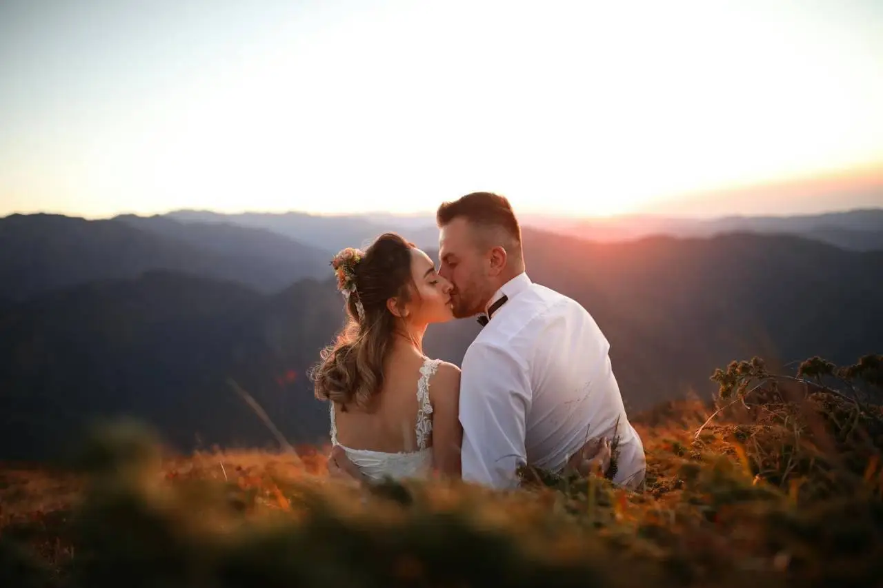 A couple kissing at sunset in the mountainous landscape of Rize, Türkiye, capturing a romantic moment.